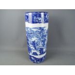A large blue and white umbrella stand decorated with mythical creatures, angels and similar,