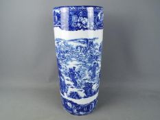 A large blue and white umbrella stand decorated with mythical creatures, angels and similar,