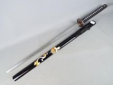 A reproduction Japanese sword with black lacquered, dragon decorated saya and dragon tsuba,