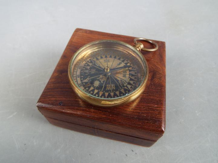 A brass compass marked 'Royal Navy' in box.