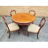 A circular topped table on carved support with four chairs.