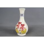 A Moorcroft solifleur vase hand painted in a floral design on a cream ground,