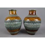 A pair of Doulton Lambeth ovoid form vases with relief decoration, impressed marks to the base,