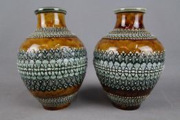 A pair of Doulton Lambeth ovoid form vases with relief decoration, impressed marks to the base,