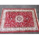 A red ground Kashmir carpet / rug with medallion pattern, approximately 240 cm x 160 cm.