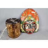 An animal skin drum and a painted tribal mask.