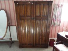 A gentleman's oak wardrobe with linen fold decoration,