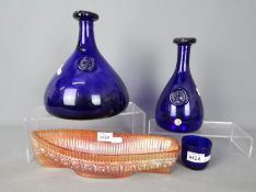 Three pieces of Kastrup-Holmegaard cobalt blue glass and a carnival glass model of a boat.