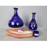 Three pieces of Kastrup-Holmegaard cobalt blue glass and a carnival glass model of a boat.