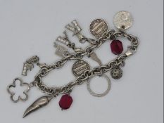 A silver charm bracelet with 14 charms Est £25 - £40