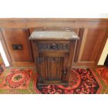 A carved oak small cupboard with single drawer above,