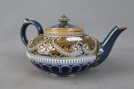 A Doulton Lambeth stoneware teapot of squat form with incised and relief decoration,