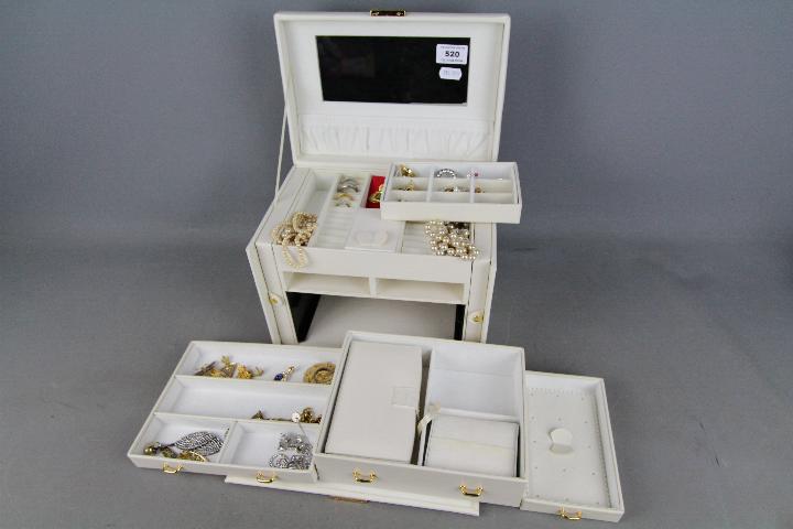 A good quality jewellery box containing a collection of costume jewellery to include rings,