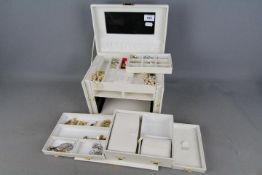 A good quality jewellery box containing a collection of costume jewellery to include rings,