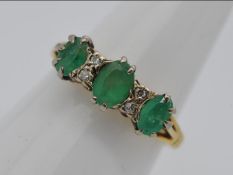 An 18ct gold, emerald and diamond set ring, size J + 1/2, approximately 3.2 grams all in.