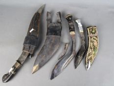 Three Kukri knives with scabbards.