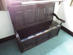 A Victorian superbly carved oak monk's bench,