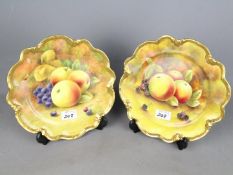 Coalport - two cabinet plates hand painted with fruit, with gadrooned gilded rims,