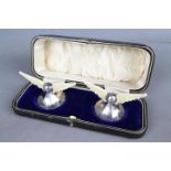 A pair of George V hallmarked silver and bone knife rests in the form of wings on splayed bases,