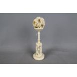 An early 20th century carved ivory puzzle ball and stand,