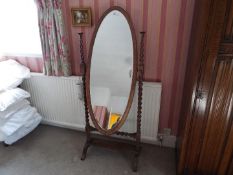 An early 20th century cheval mirror, the oval glass with bevel edge,