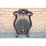 A Victorian Dinner Gong and beater in carved hardwood frame,