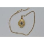A 9ct gold stone set locket pendant on fine chain stamped 9kt (44 cm length), approximately 3.