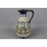 A Doulton stoneware jug with relief decoration, no impressed marks, incised monogram for John Broad,