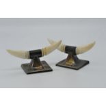 An Edward VII pair of silver and ivory knife rests formed as a pair of horns on a square base,