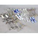 Twelve pairs of knife rests to include silver plated, cut glass, blue and white ceramic examples.