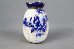 A Doulton Burslem vase of lobed form with blue floral and gilt decoration against a white ground, c.