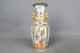A 19th century Asian twin-handled vase with flared rim, hand painted with images of figures, birds,