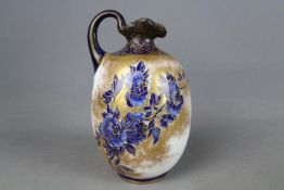 An early 20th century Royal Doulton jug decorated with blue floral sprays against a gilt and white