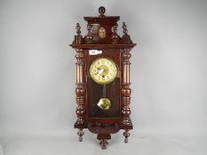 A small wall clock with key and pendulum.