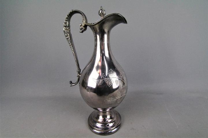 A large silver plated wine ewer with chased decoration of fruiting vine,