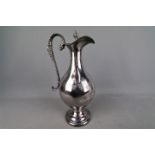 A large silver plated wine ewer with chased decoration of fruiting vine,