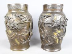 A pair of Oriental bronze vases with applied serpents and dragons, 24.