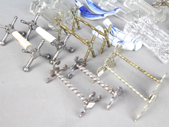 Twelve pairs of knife rests to include silver plated, cut glass, blue and white ceramic examples. - Image 2 of 3