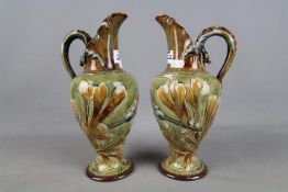 Doulton Lambeth - A set of two Frank Butler stoneware ewers decorated with an underwater scene and