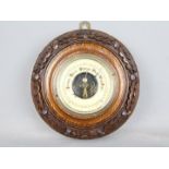 An oak cased barometer with oak leaf carved detail,