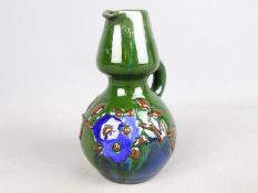 Elton Studio Ware - a jug with floral decoration on a green ground,