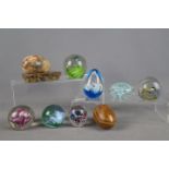 Seven paperweights to include Millrace, Caithness and similar, stone eggs and other.