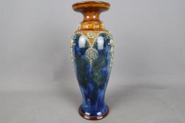 A Royal Doulton stoneware vase, stylised floral decoration in relief against a mottled blue ground,