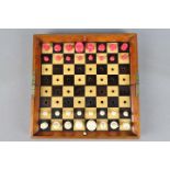 A Jaques & Son 'In Statu Quo' travelling chess set with natural and red stained pieces,