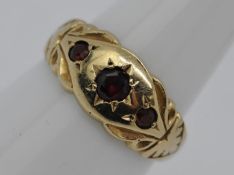 A 9ct gold and garnet, three stone gypsy set ring, size L, approximately 2.5 grams all in.