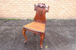 An early 19th century mahogany hall chair,