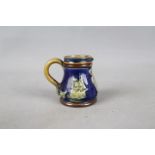 Royal Doulton - A miniature Royal Doulton stoneware commemorative jug with green glazed portrait of