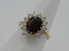 A lady's hallmarked 9 carat gold cluster ring, th e central oval stone surrounded by 14 cz stones,