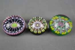 Two Perthshire Glass millefiori paperweights, one 6 cm (d) the other 7 cm (d) and one similar.