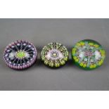 Two Perthshire Glass millefiori paperweights, one 6 cm (d) the other 7 cm (d) and one similar.